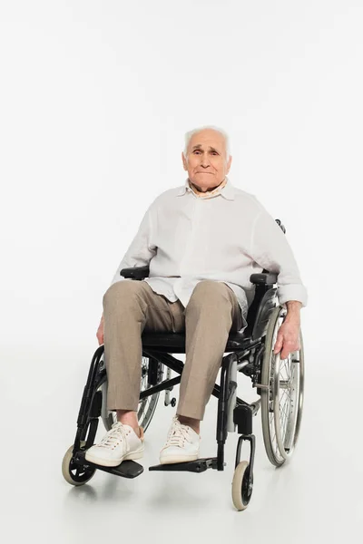 Exhausted elderly man in casual clothes sitting in wheelchair on white — Stock Photo