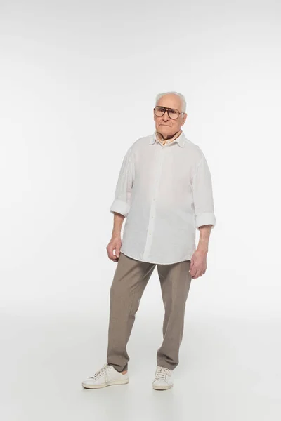 Full length view of smiling elderly man in glasses and casual clothes isolated on white — Stock Photo