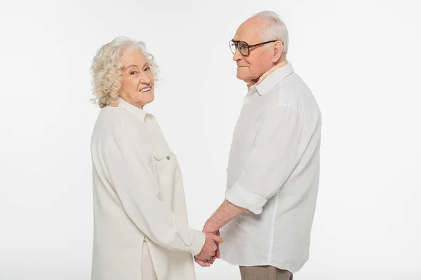 Heureux couple âgé en vêtements décontractés debout avec les mains tenant isolé sur blanc — Photo de stock