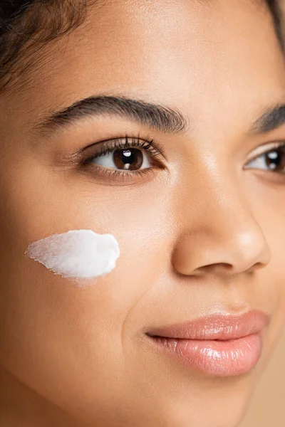 Close up of african american woman with face cream on cheek — Stock Photo