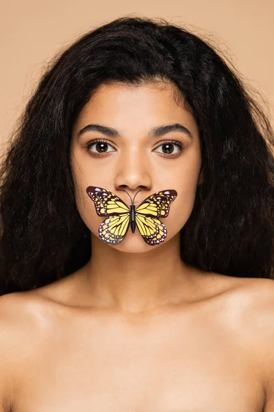 Bella afroamericana giovane donna con farfalla sulle labbra isolata sul beige — Foto stock
