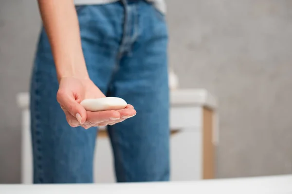 Vista recortada del jabón en la mano de la mujer borrosa - foto de stock