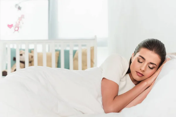 Morena mujer durmiendo en blanco ropa de cama - foto de stock