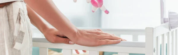 Cropped view of woman standing near baby bed at home, banner — Stock Photo