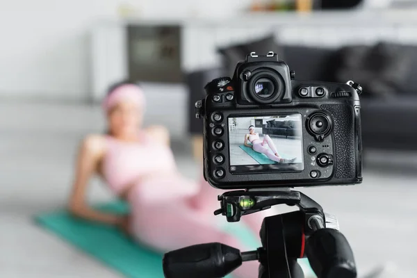 Foco seletivo da câmera digital perto blogueiro desfocado esportes em casa — Fotografia de Stock