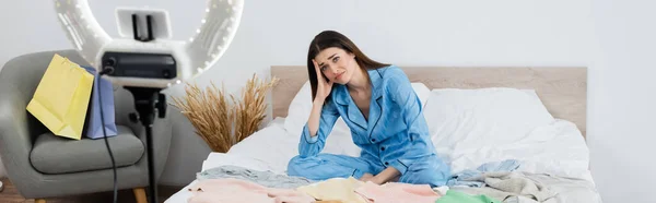 Sconvolto fashion blogger vicino al porta telefono sfocato con anulare e borse della spesa in camera da letto, banner — Foto stock