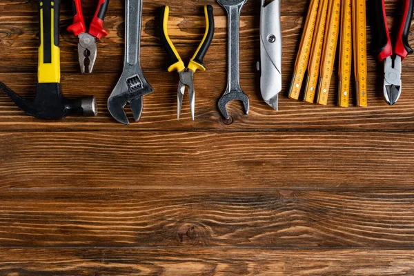 Vue de dessus des différents outils sur la surface en bois, concept de jour de travail — Photo de stock