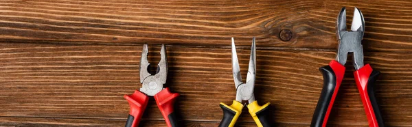 Top view of pliers and wire cutters on wooden surface, labor day concept, banner — Stock Photo