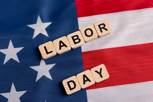 Top view of wooden cubes with labor day lettering on usa flag — Stock Photo