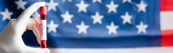 Vista cortada da pessoa com teste de coronavírus positivo perto da bandeira dos EUA borrada, bandeira — Fotografia de Stock