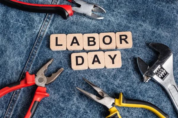 Top view of cubes with labor day lettering near various tools on denim cloth — Stock Photo