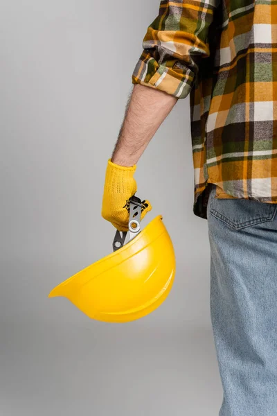 Back view of cropped workman holding hardhat isolated on grey, labor day concept — Stock Photo