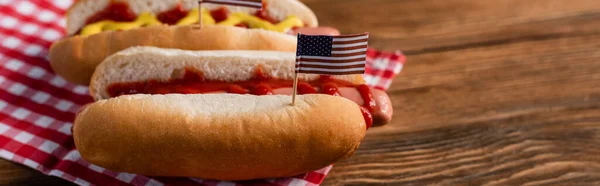 Nieblas calientes sabrosas con banderas americanas pequeñas en la mesa de madera, bandera - foto de stock