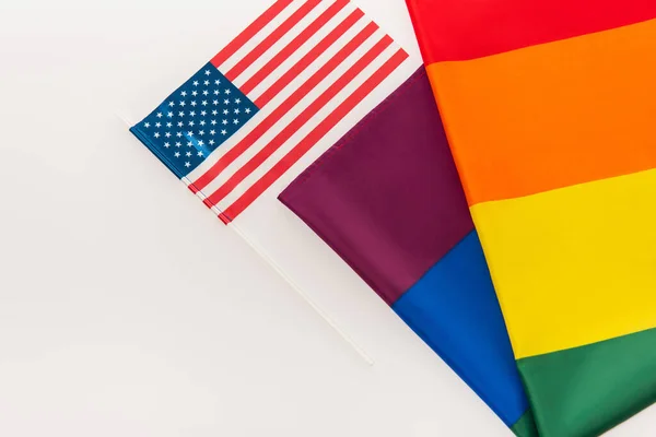 Vista de ángulo alto de banderas americanas y lgbt aisladas en blanco - foto de stock