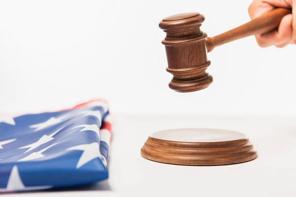 Cropped view of judge holding gavel near american flag on white — Stock Photo