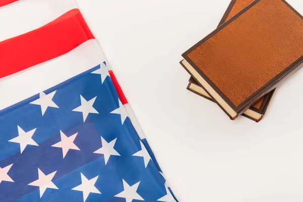 Vista superior da bandeira americana perto de livros isolados em branco — Fotografia de Stock