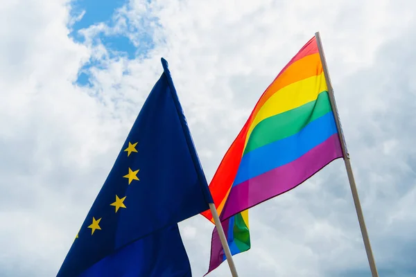 Banderas americanas y lgbt contra el cielo con nubes - foto de stock