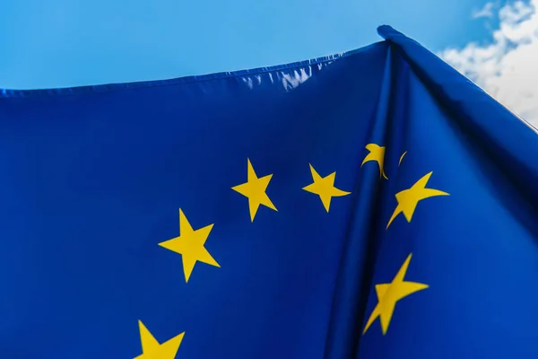 Vista de ángulo bajo de la bandera azul de la unión europea contra el cielo - foto de stock