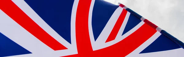 Close up view of national flag of united kingdom with red cross against sky, banner — Stock Photo