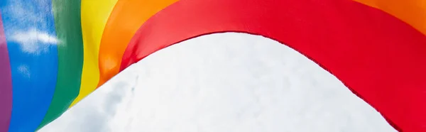 Bottom view of colorful lgbt flag against cloudy sky, banner — Stock Photo