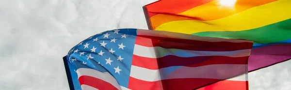 Low angle view of american and lgbt flags against sky, banner — Stock Photo