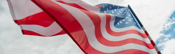 Vue à angle bas du drapeau américain avec des étoiles et des rayures contre le ciel nuageux, bannière — Photo de stock