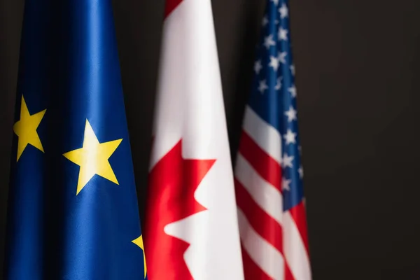 Blue european union, canadian and american flags isolated on black — Stock Photo