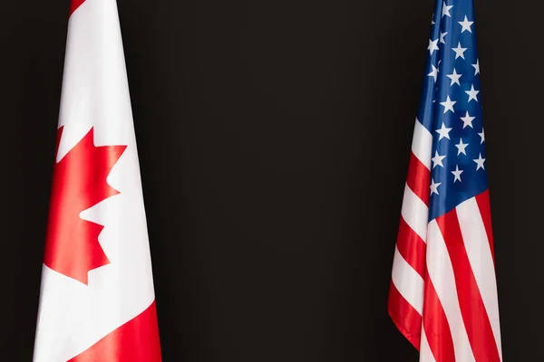 Canadian and american flags isolated on black — Stock Photo