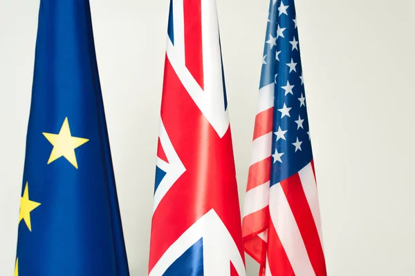 Banderas de EE.UU., gran unión británica y europea aislada sobre gris - foto de stock