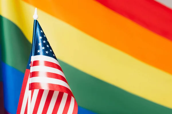 Primer plano de la bandera americana con colores lgbt borrosos en el fondo, concepto de derechos de igualdad - foto de stock