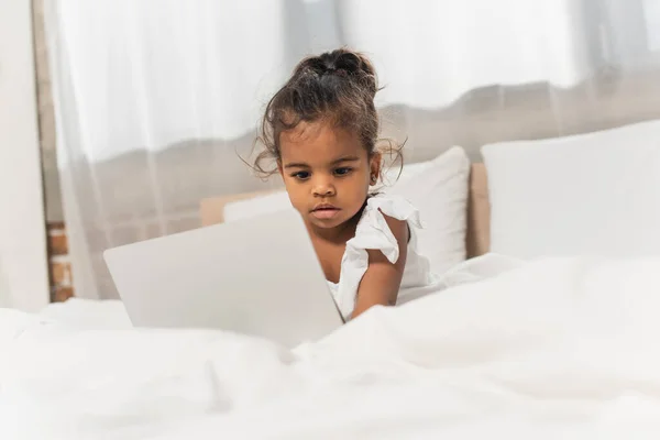 Ребенок африканский американец девушка с помощью ноутбука в спальне — стоковое фото