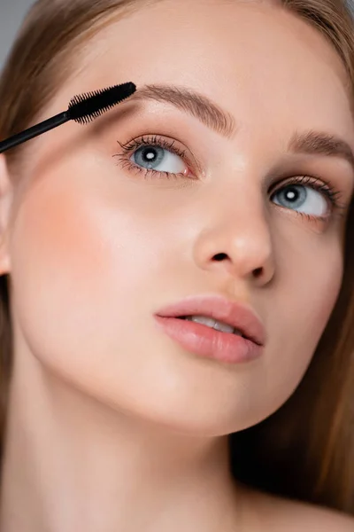 Close up of young woman applying mascara — Stock Photo