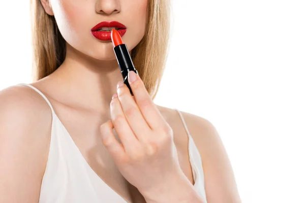 Abgeschnittene Ansicht einer jungen Frau, die Lippenstift isoliert auf Weiß aufträgt — Stockfoto