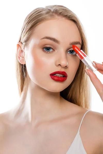 Pretty young woman with red lips and blue eyes holding lipstick tube isolated on white — Stock Photo