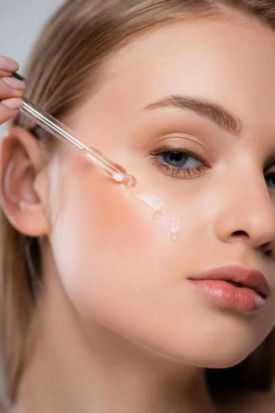 Close up of pretty woman applying vitamin c serum with pipette — Stock Photo