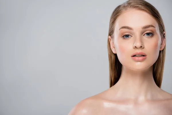 Young woman with bare shoulders and perfect skin looking at camera isolated on grey — Stock Photo