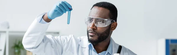 African american scientist in safety goggles holding test tube, banner — Stock Photo