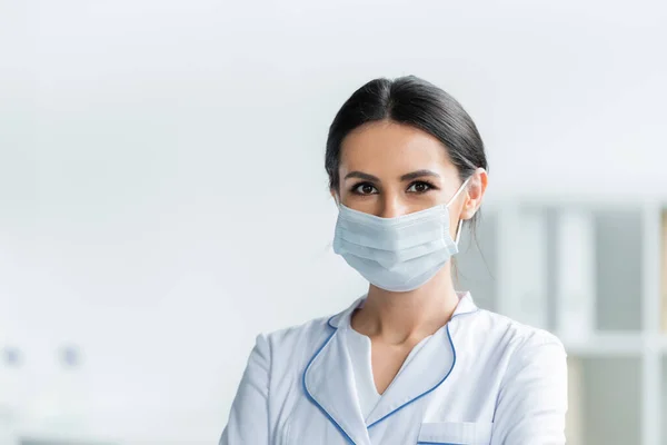 Medico in maschera protettiva in piedi in clinica — Foto stock