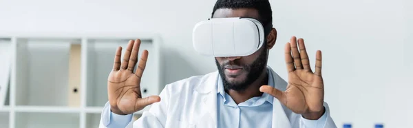 African american doctor using vr headset in clinic, banner - foto de stock