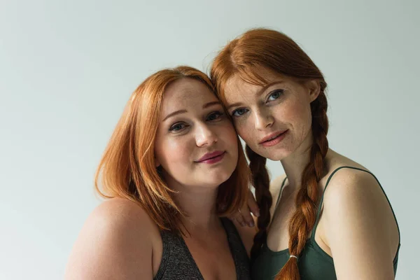 Redhead sportswomen looking at camera isolated on grey — Stock Photo