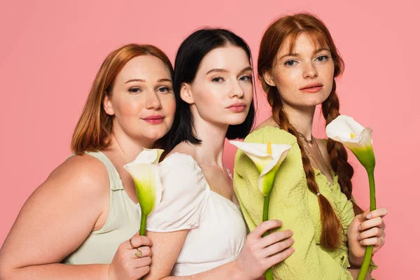 Pretty body positive women holding flowers isolated on pink — Stock Photo