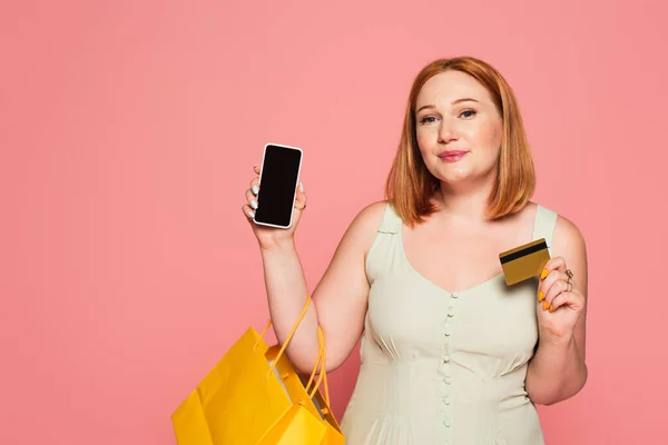 Cuerpo mujer positiva con bolsas de la compra, teléfono inteligente y tarjeta de crédito aislado en rosa - foto de stock