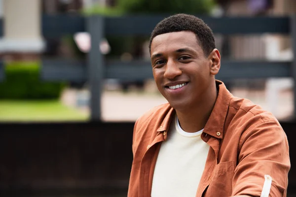 Молодий афроамериканський чоловік дивиться на камеру і посміхається на відкритому повітрі — стокове фото