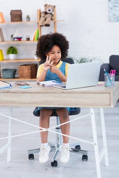 African american kid counting on fingers during online education on laptop at home — Stock Photo