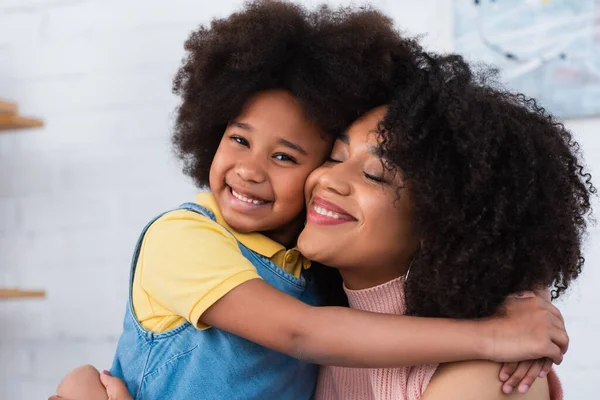 Afroamericano figlia abbraccio sorridente genitore a casa — Foto stock