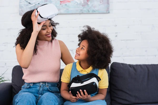 African american mother and child holding virtual reality headsets at home — Stock Photo
