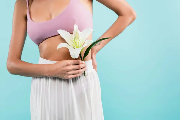 Vista parziale della donna in bianco pareo tenuta giglio fiore isolato su blu, concetto di bellezza — Foto stock