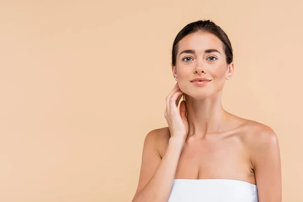 Femme heureuse avec peau parfaite posant avec la main près du cou isolé sur beige, concept de beauté — Photo de stock