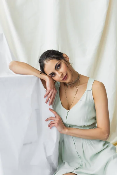 Morena e bonita mulher olhando para a câmera no branco — Fotografia de Stock