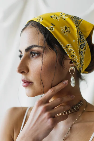 Woman in yellow headscarf looking away while posing on white — Stock Photo